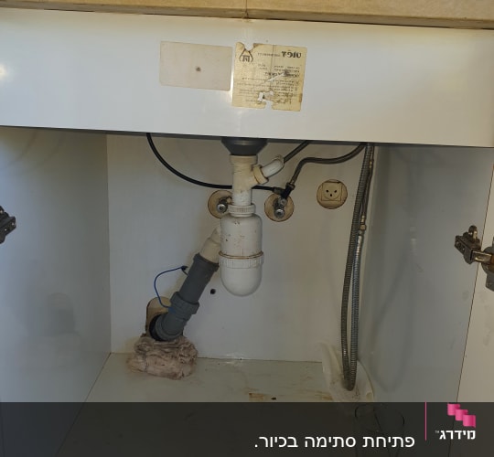 צנרת מתחת לכיור עם חיבורים וצינור גמיש